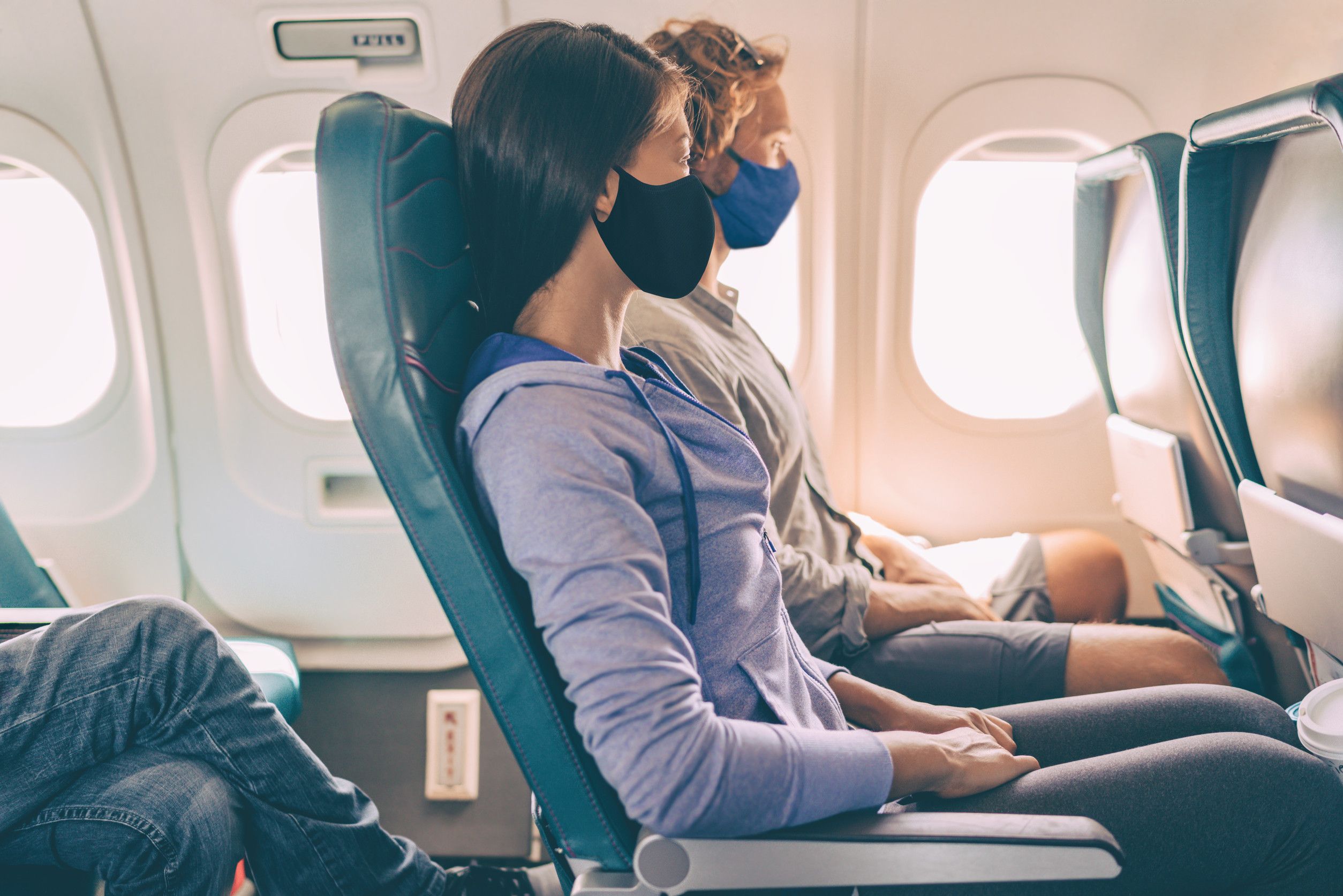 Coppia di turisti indossa mascherine durante un volo di vacanza all'interno dell'aereo Coronavirus Coppia di turisti indossa mascherine durante un volo di vacanza all'interno dell'aereo Coronavirus