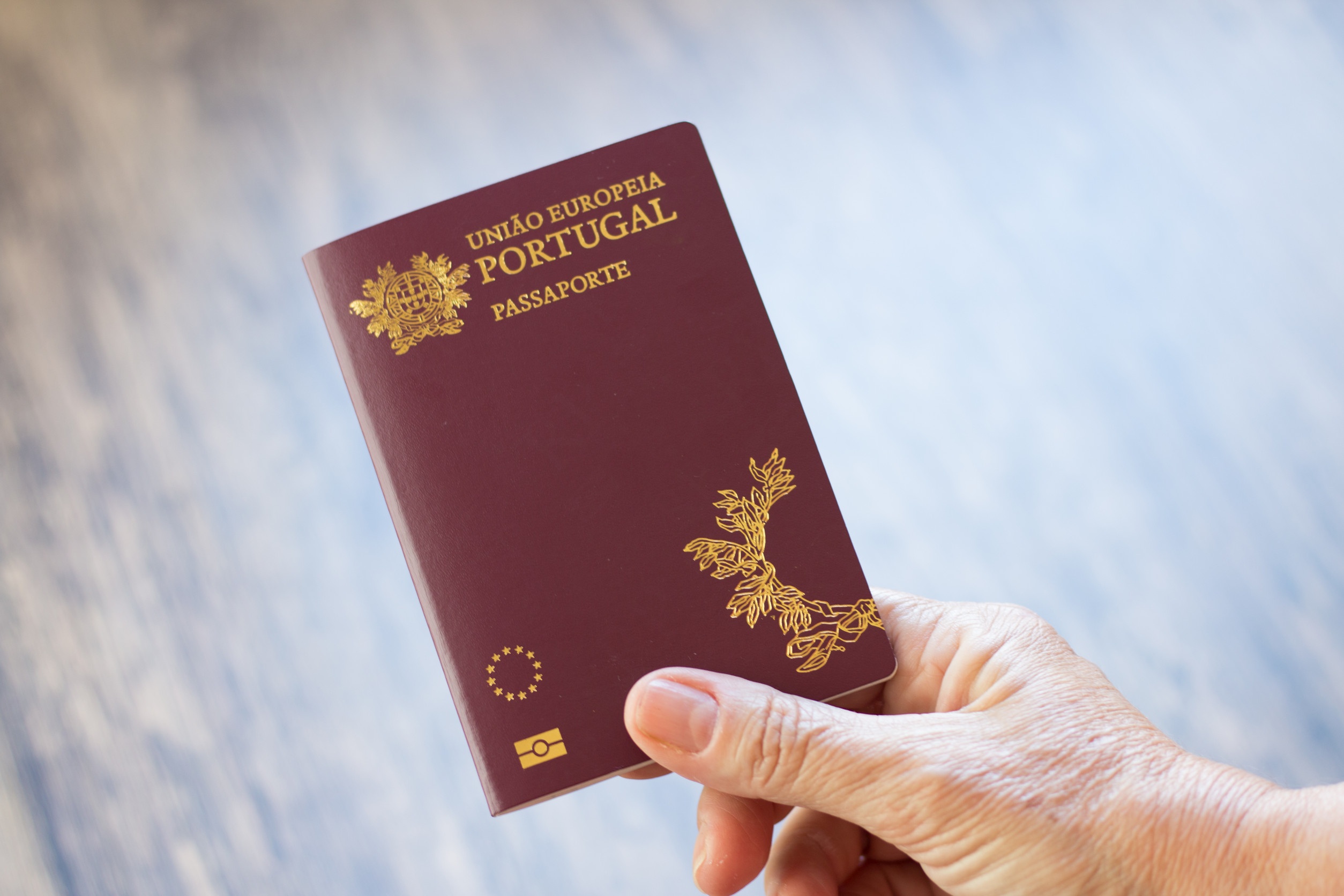 Mano che tiene un passaporto portoghese Mano che tiene un passaporto portoghese