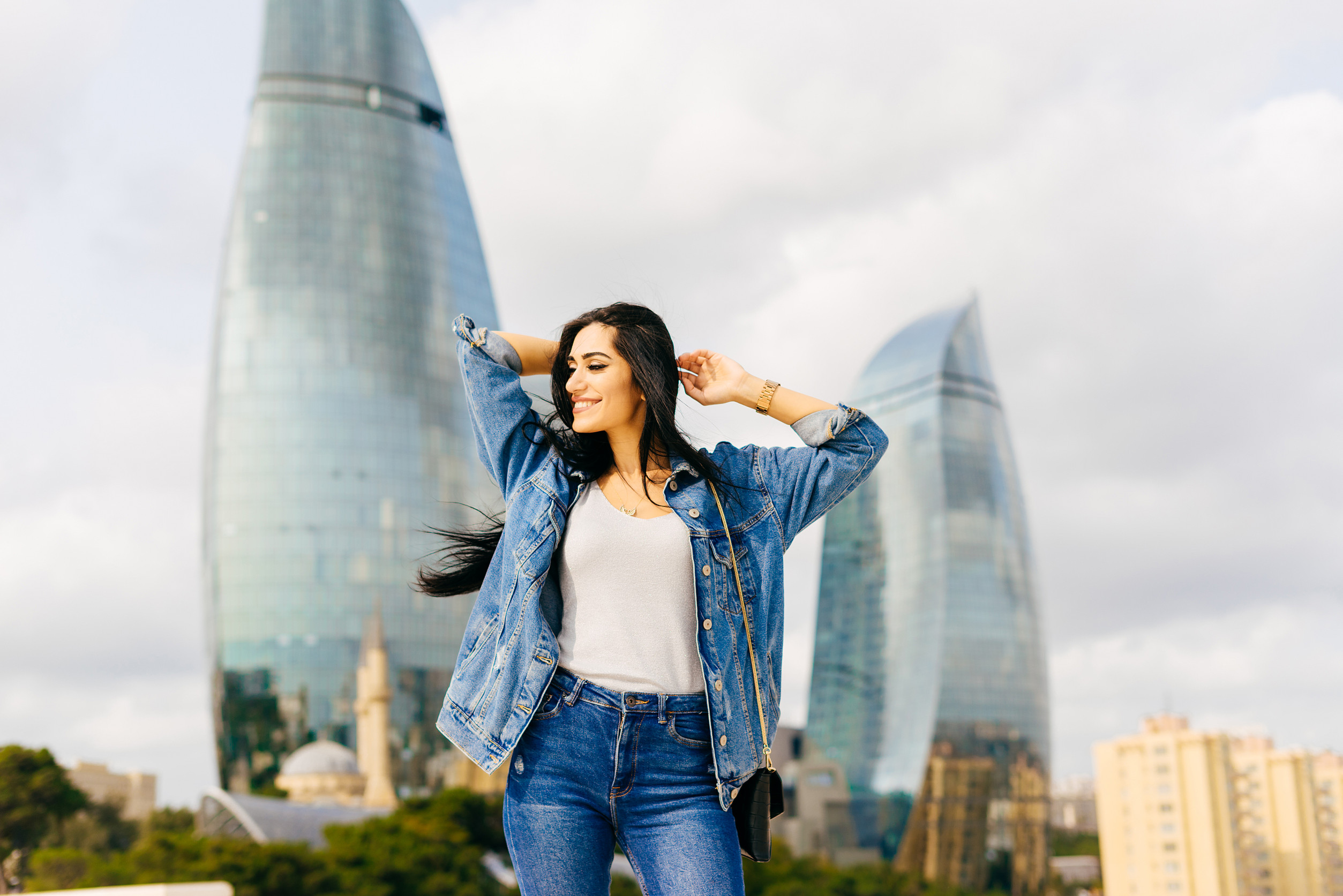 una ragazza felice ed elegante dai capelli neri cammina lungo l'Azerbaijan in posa sullo sfondo una ragazza felice ed elegante dai capelli neri cammina lungo l'Azerbaijan in posa sullo sfondo