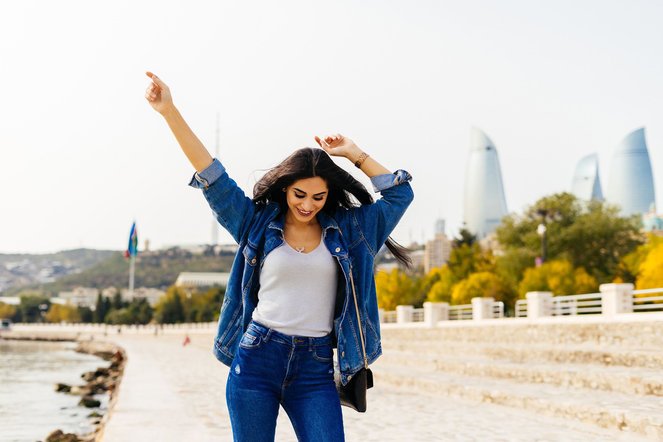 Donna felice con una giacca di jeans che cammina per la città Donna felice con una giacca di jeans che cammina per la città