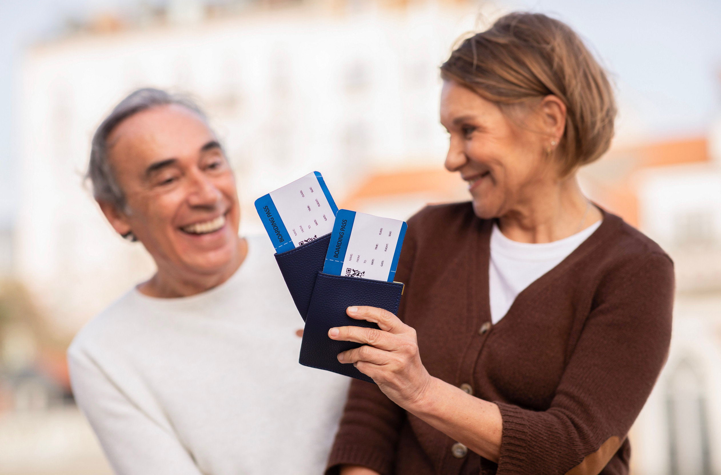 Coppia di turisti senior con carte d'imbarco e passaporti all'aperto Coppia di turisti senior con carte d'imbarco e passaporti all'aperto