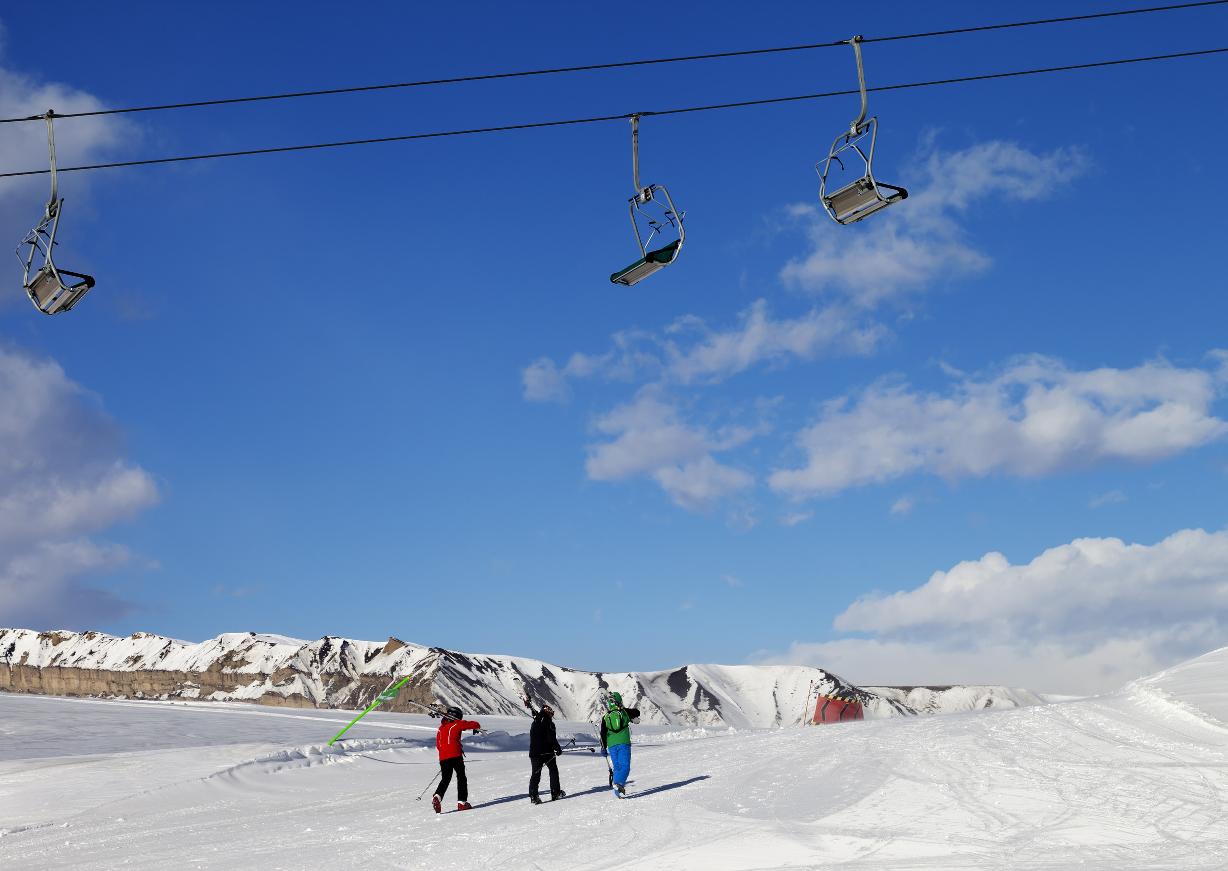 Tre sciatori sulle piste in una giornata di sole, Monte Shahdagh Qusar, Grande Caucaso, Distretto di Azerbaijan Tre sciatori sulle piste in una giornata di sole, Monte Shahdagh Qusar, Grande Caucaso, Distretto di Azerbaijan
