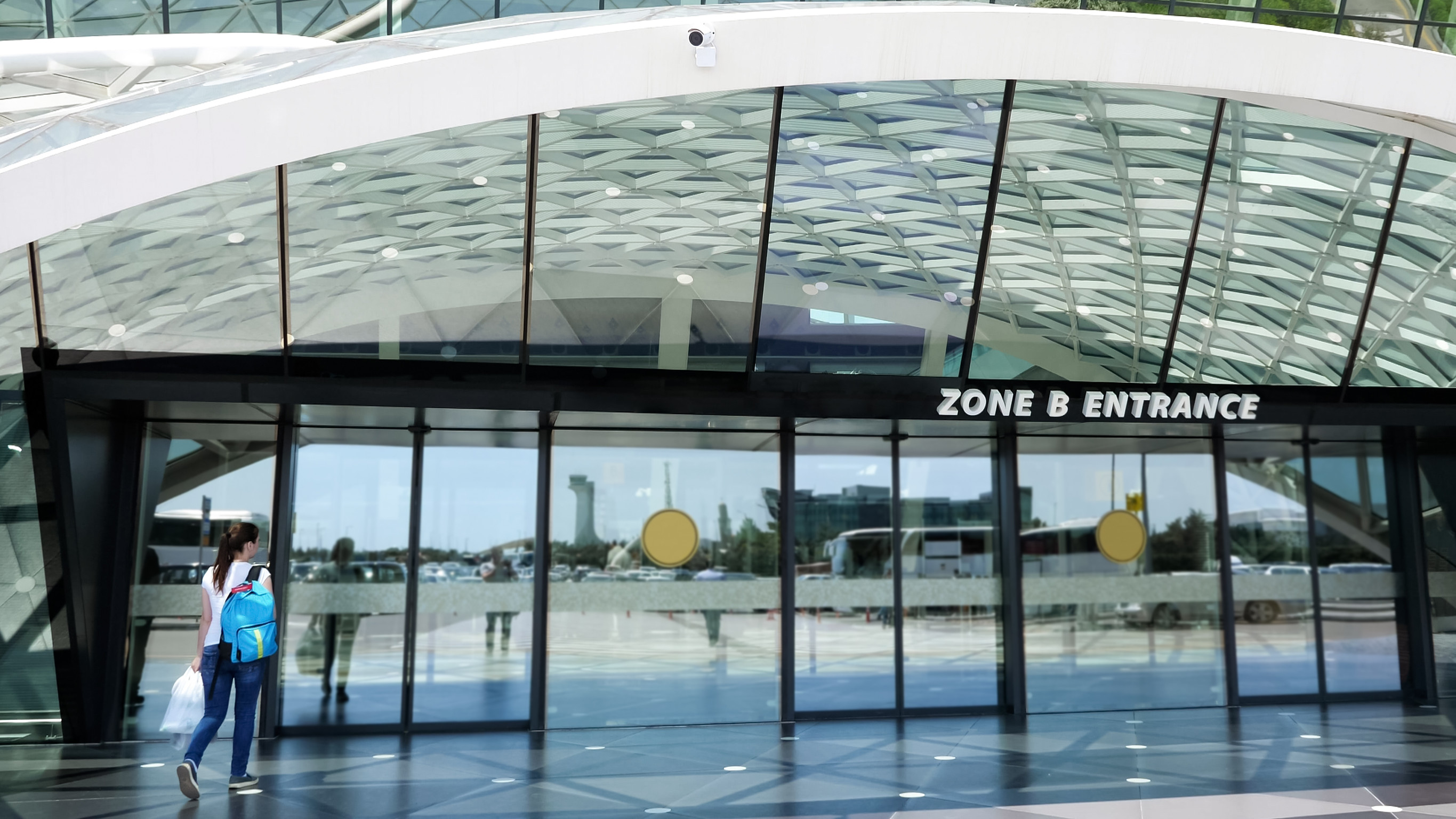 vista all'ingresso dell'aeroporto con una donna che entra dalla porta del nuovo e moderno terminal dell'aeroporto vista all'ingresso dell'aeroporto con una donna che entra dalla porta del nuovo e moderno terminal dell'aeroporto
